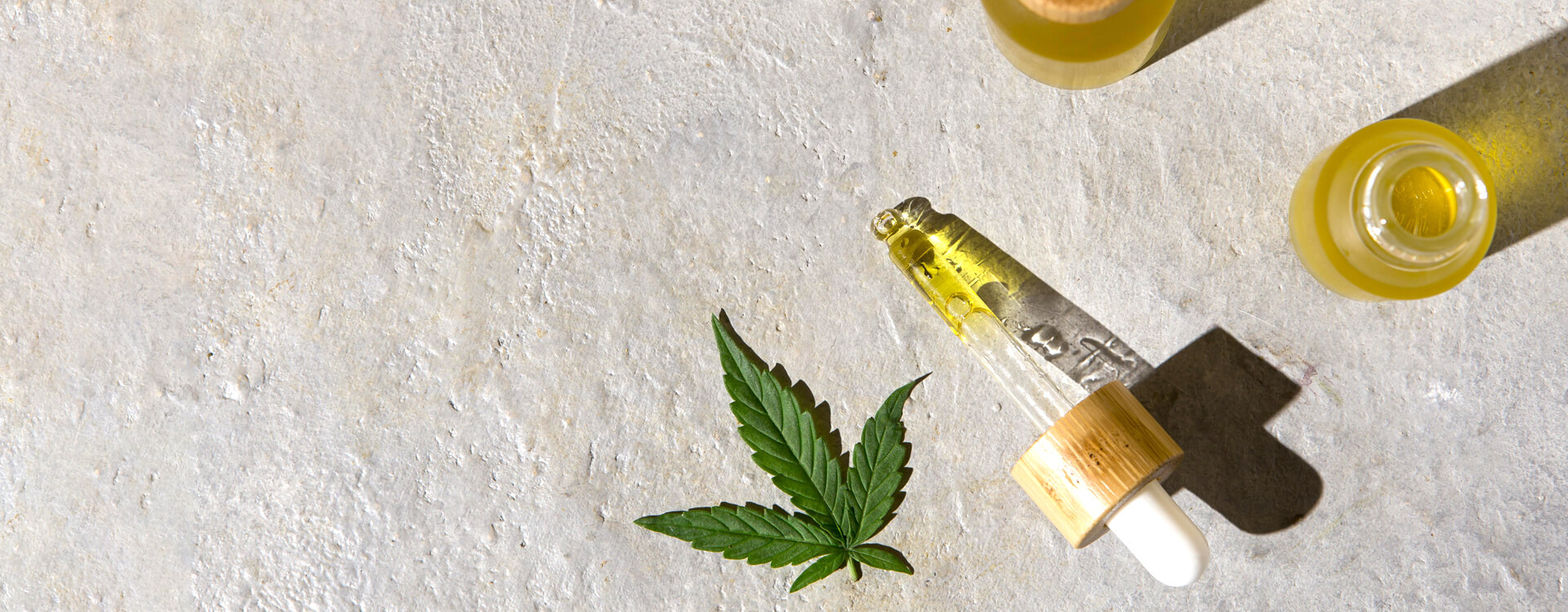 CBD olej: lístok konope, pipeta a fľaštička s olejom