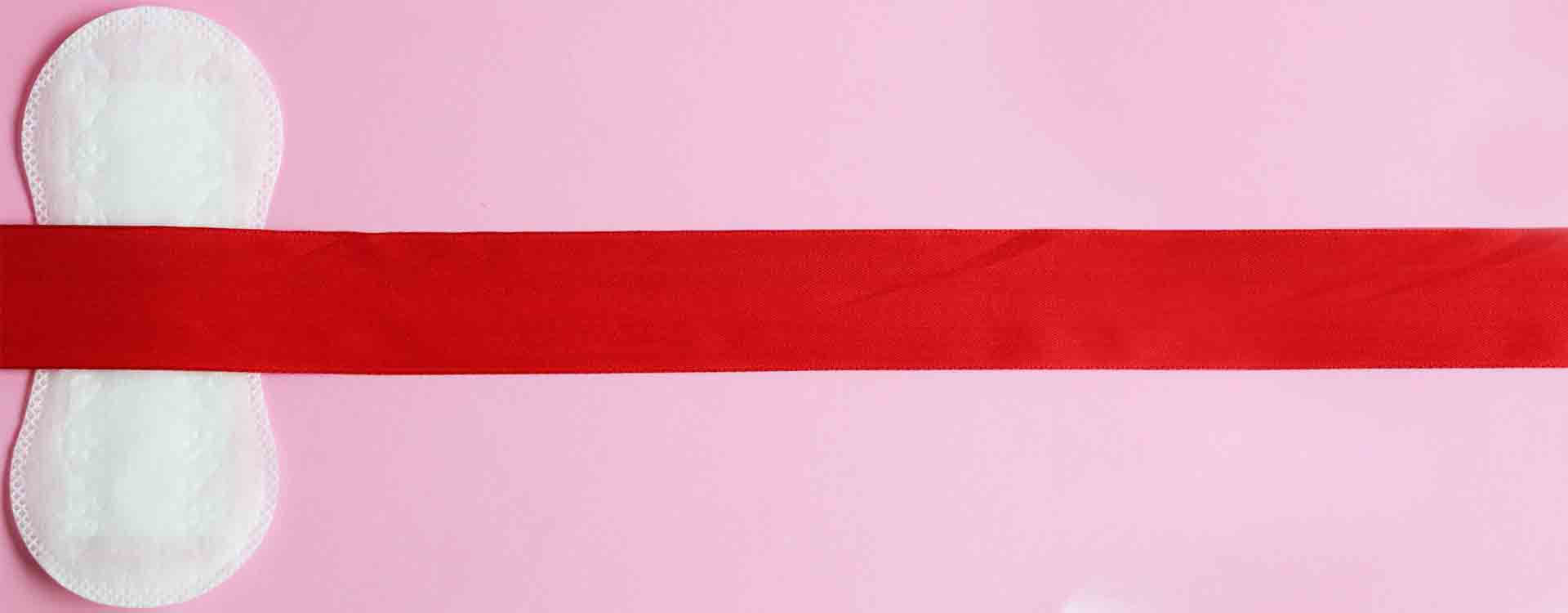 ilustračný obrázok - menštruácia: hygienická vložka prekrytá červenou stuhou