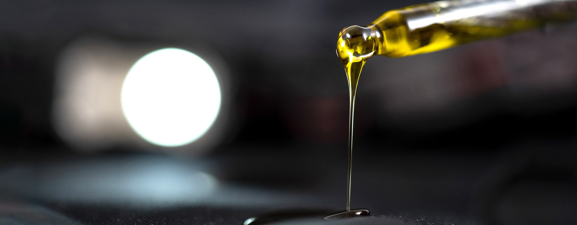 CBD olej - detailný záber na olej lejúci sa z pipetky